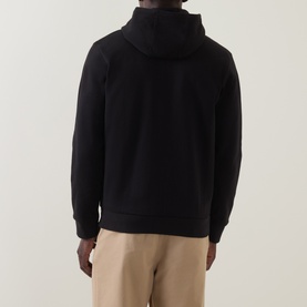 Model wearing Boss Black Casual black cotton zip-through hoodie, back view, styled with beige trousers.