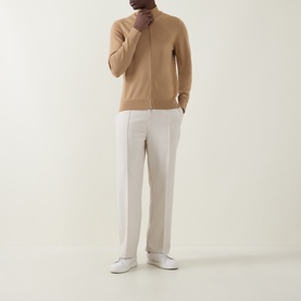 Model wearing Boss Black Casual Balonso Logo Zip Sweater in medium beige with mock neck, styled with white trousers and white trainers.