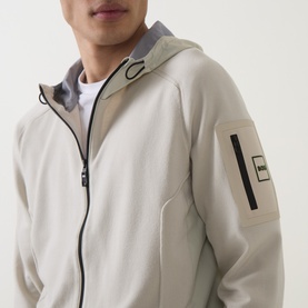 Model wearing Boss Green Label Light Beige casual jacket with grey hood lining, zip fastening, and sleeve badge detail, styled over white tee.