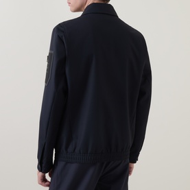 Model wearing Boss Green Label Dark Blue Casual Jacket, rear view, showing badge detail on sleeve, with matching dark trousers