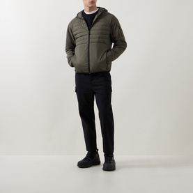 Model wearing Boss Green Label Urbanex Hybrid Quilted Jacket in Open Green with hooded collar, styled with black cargo trousers and dark trainers.