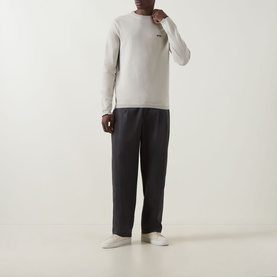 Model wearing Boss Green Label Ever-X Logo Sweater in Light Beige, ribbed crew neck, long sleeves, styled with dark trousers and white trainers.