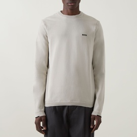 Model wearing Boss Green Label Ever-X Logo Sweater in light beige, crew neck with small contrast logo, ribbed cuffs, styled with dark trousers.
