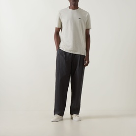 Model wearing Boss Green Label Swing Printed Logo T-Shirt in Light Beige with dark tailored trousers and white trainers.