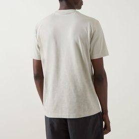 Model wearing Boss Green Label Swing Printed Logo T-Shirt in light beige, rear view, crew neck, short sleeves, with dark trousers.