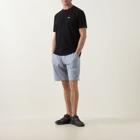 Model wearing Boss Green Label black crew neck cotton T-shirt with light blue shorts and black chunky trainers.