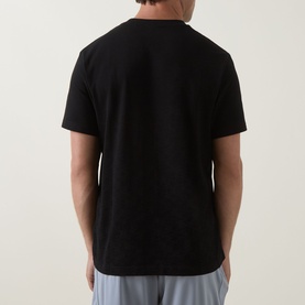 Model wearing Boss Green Label black crew neck T-shirt, back view, styled with light grey trousers