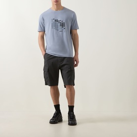 Model wearing Boss Green Label dark grey crew neck T-shirt with graphic print, styled with black cargo shorts and chunky trainers.