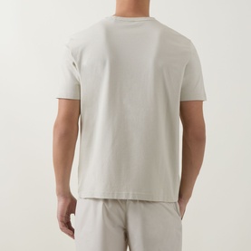 Model wearing Boss Green Label light beige crew neck T-shirt, rear view, styled with matching beige shorts.