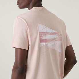Model wearing Boss Green Label light pastel orange crew neck T-shirt, back view showing geometric graphic print detail.