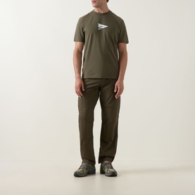 Model wearing Boss Green Label Open Green crew neck T-shirt with flag graphic, styled with matching cargo trousers and grey trainers.