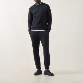 Model wearing Boss Green Label Salbo Logo Sweatshirt in dark blue with matching joggers and trainers.