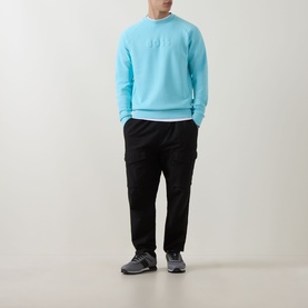 Model wearing Boss Green Label Open Blue cotton crew neck sweatshirt with black cargo trousers and grey trainers