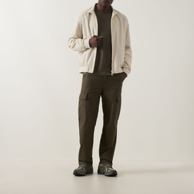 Model wearing Boss Green Label Open Green crew neck T-shirt, styled with cream zip jacket, khaki cargo trousers and grey trainers.