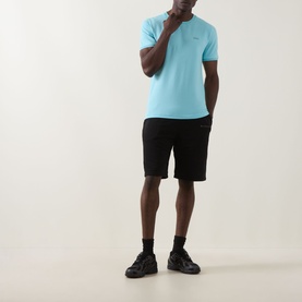 Model wearing Boss Green Label Taul Logo T-Shirt in Open Blue with black shorts and black trainers