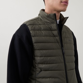 Model wearing Boss Green Label Urbanex Hybrid Gilet in Open Green, quilted sleeveless design with zip fastening, styled with black sweatshirt