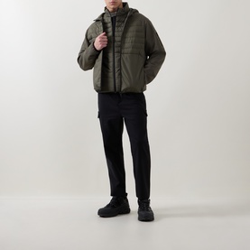 Model wearing Boss Green Label Urbanex Hybrid Gilet in Open Green, styled with black cargo trousers and black boots