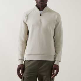 Model wearing Boss Green Label Logo Half-Zip Sweatshirt in light beige with funnel neck and half-zip, styled with olive trousers.