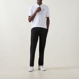 Model wearing Boss Green Label Ever-X Logo Zip Polo Shirt in white with black trousers and white trainers.