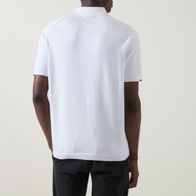 Model wearing Boss Green Label Ever-X Logo Zip Polo Shirt in white, rear view, short sleeves, black trousers