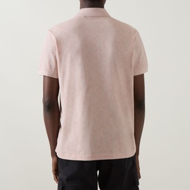Model wearing Boss Green Label Swing Printed Logo Polo Shirt in light pastel orange, rear view, short sleeves, styled with dark trousers