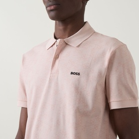 Model wearing Boss Green Label Swing Printed Logo Polo Shirt in light pastel orange, short sleeves, embroidered logo at chest
