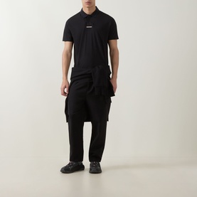 Model wearing Boss Green Label black modal polo shirt with small chest logo, styled with black cargo trousers and dark chunky trainers