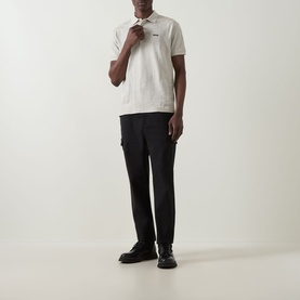 Model wearing Boss Green Label Light Beige polo shirt with black cargo trousers and black lace-up shoes