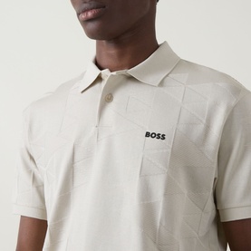 Model wearing Boss Green Label Light Beige polo with geometric jacquard pattern and logo chest print, short sleeves visible