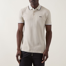 Model wearing Boss Green Label light beige cotton polo shirt with contrast tipped collar and cuffs, styled with black trousers