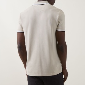 Model wearing Boss Green Label light beige cotton polo, back view, with navy tipping detail on collar and cuffs