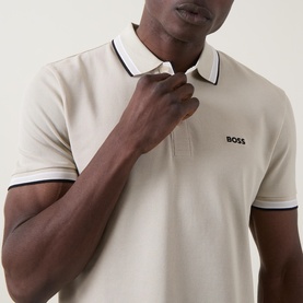 Model wearing Boss Green Label light beige cotton polo with contrast navy and white tipped collar and cuffs, BOSS chest logo
