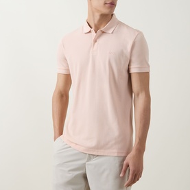 Model wearing Boss Green Label polo in light pastel orange, 100% cotton piqu&eacute; with ribbed collar and short sleeves, styled with grey trousers