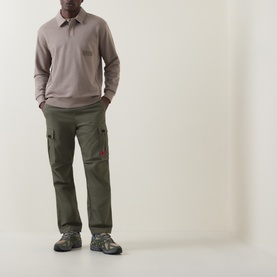Model wearing Boss Green Label Light/Pastel Green cotton polo, styled with olive cargo trousers and grey hiking trainers.