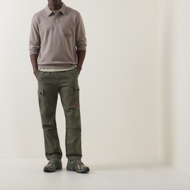 Model wearing Boss Green Label Light/Pastel Green cotton polo with olive cargo trousers and grey hiking shoes.