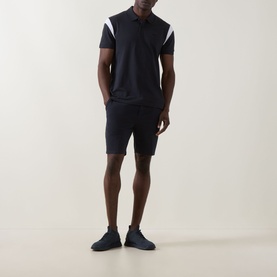 Model wearing Boss Green Label dark blue polo with white shoulder panel detail, styled with matching navy shorts and trainers