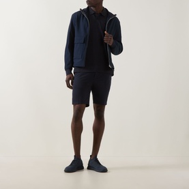 Model wearing Boss Green Label dark blue polo with matching navy zip-through hoodie and shorts, styled with navy trainers.