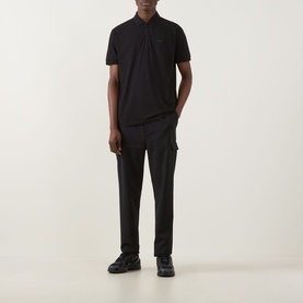 Model wearing Boss Green Label Urban Tech Logo Polo Shirt in black with black cargo trousers and black trainers.