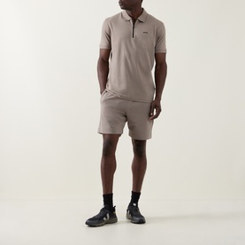 Model wearing Boss Green Label light pastel green polo shirt with matching shorts and black trainers