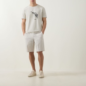 Model wearing Boss Green Label Light Beige shorts with elasticated waist, styled with a grey graphic tee and cream trainers.