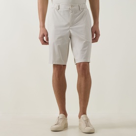 Model wearing Boss Green Label light beige shorts with belt loops and side pockets, styled with white trainers.