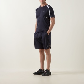 Model wearing Boss Green Label dark blue polyester shorts with matching navy T-shirt and black trainers