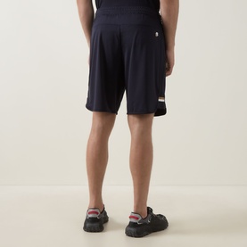 Model wearing Boss Green Label dark blue polyester shorts, rear view, styled with black trainers