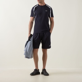 Model wearing Boss Green Label dark blue polyester shorts with matching navy T-shirt, white shoulder detail, and black trainers