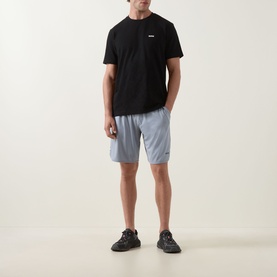 Model wearing Boss Green Label Game Nine Logo Active Shorts in dark grey with black tee and black trainers