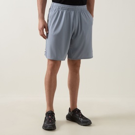 Model wearing Boss Green Label Game Nine Logo Active Shorts in dark grey with drawstring waist and stripe detail, styled with black trainers