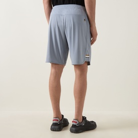 Model wearing Boss Green Label Game Nine Logo Active Shorts in dark grey, shown from behind, styled with black trainers.