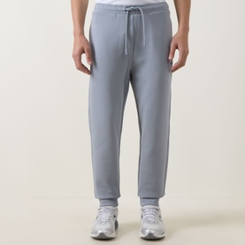 Model wearing Boss Green Label Hadiko Logo Track Pants in dark grey, elasticated drawstring waist, cuffed hem, styled with white trainers