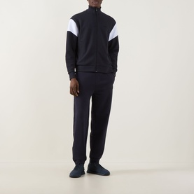 Model wearing Boss Green Label JT Logo Sweatpants in dark blue, slim-leg with cuffed ankles, styled with matching zip-through track jacket and