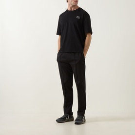 Model wearing Boss Green Label black sweat bottoms in cotton-polyester blend, styled with matching black T-shirt and dark trainers.
